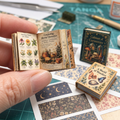Illustrated miniature botanical book held open beside assembled book examples